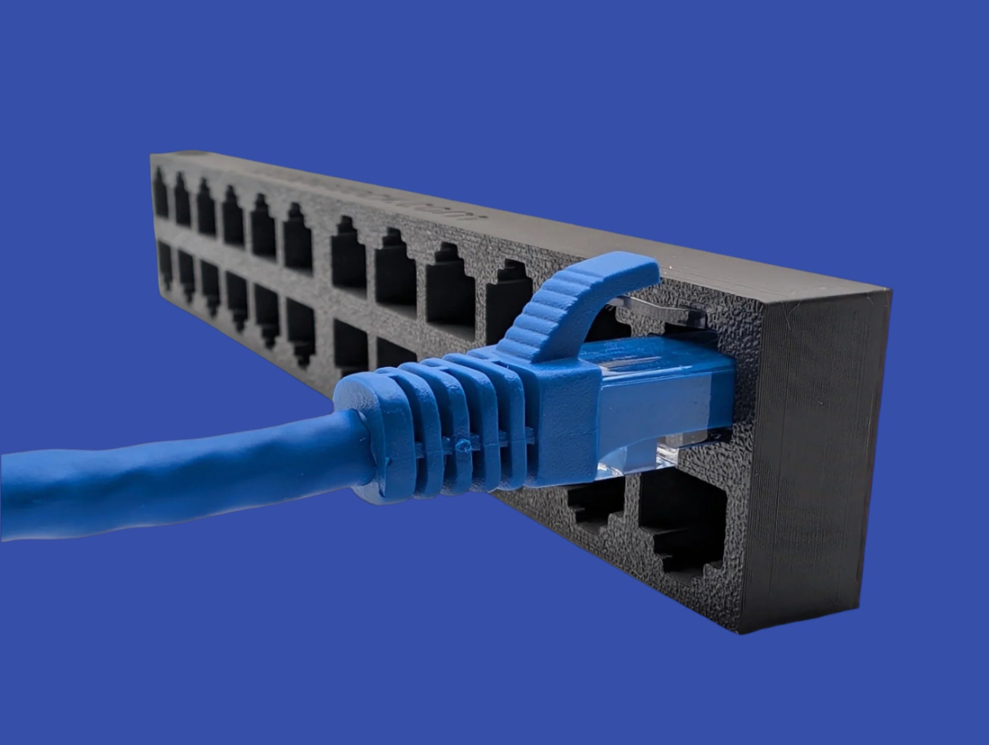 An image of a 24-port EZ Cable Dock with a single Ethernet cable inserted into one of its RJ45 ports. The dock, designed for temporary cable organization, resembles a network switch or patch panel but contains no electronic components